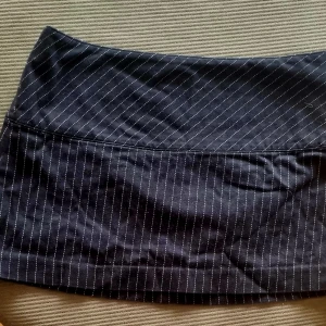 Kort randig kjol. - Kort randig kjol, dragkedja bak.  