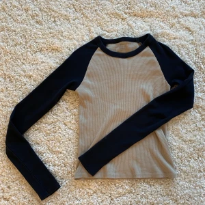 Brandy Melville Topp - Säljer denna topp ifrån brandy Melville. Tröjan heter Bella på hemsidan och på sista bilden ser ni modellen på tröjan, tyvärr finns inte just den färgen kvar, därför annan bild. Aldrig använd, så super skick! Priset kan absolut diskuteras 