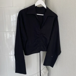 Svart blus - Svart blus från Gina Tricot, storlek M. Snygga detaljer med justerbart snöre framtill. Perfekt dag-till-kväll blus! 🥰