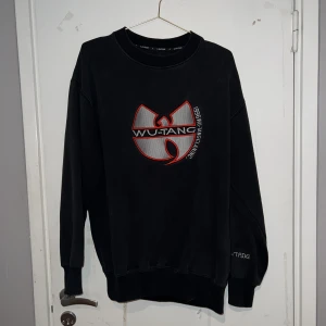Wu-Tang sweatshirt - Unik och så snygg Wu-Tang sweatshirt! I snygg urtvättad svart färg med fina detaljer. Storlek L men sitter snyggt på mig med storlek M. I använt men gott skick. Betalningen sker via Swish.