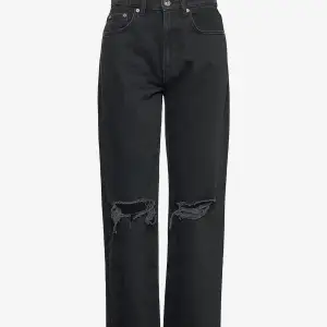 Ett par svarta raka jeans med hål på knäna. Högmidjade byxor som inte kommit till användning. Från GinaTrikot🤍