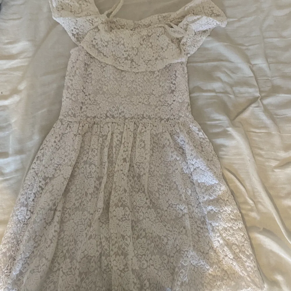 Säljer en vit blommig klänning som jag bara använt en gång på en skolavslutning. . Klänningar.