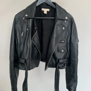 Skinnjacka från H&M - Svart supersnygg skinnjacka från H&M, sparsamt använd. I storlek 40, sitter något oversized och slutar vid höfterna på mig som är 165 cm. 