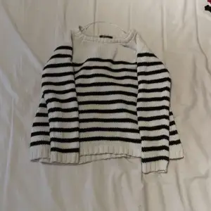 En stickat tröja i svart och vit från Gina tricot i storlek S. 