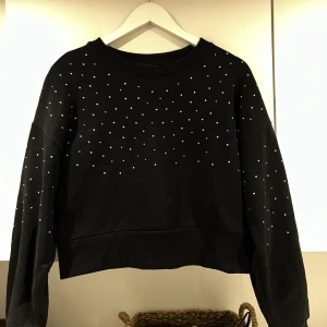 Sweatshirt med detaljer  - En svart sweatshirt med ”bling” detaljer på. I fint skick💕 Storlek M men passar på mig som oftast brukar ha S