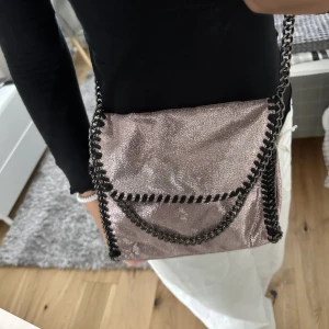 Stella McCartney liknande väska  - Rosaglittrig Stella McCartney liknande väska. Köpt här på Plick. Aldrig använd då den inte riktigt är min stil, nyskick och inga defekter. 🤍 