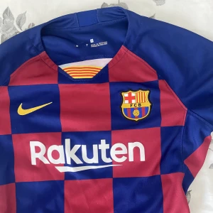 FC Barcelona tröja - Säljer en äkta FC Barcelona dam tröja i storlek S då den ej kommer till användning o är lite liten på mig. En gammal modell och har inget nummer eller namn på ryggen. Väldigt fint skick o inga defekter! Pris kan diskuteras