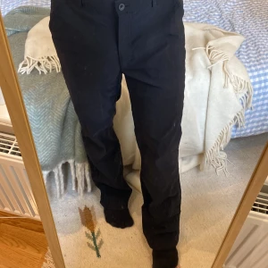 Raka Kostymbyxor  - Ett par svarta kostymbyxor med straight leg i ett stretchmaterial. Sitter jättesnyggt och de är supersköna. Skicket är väldigt bra och de är i storleken 40 vilket ungefär är W28-30 L32