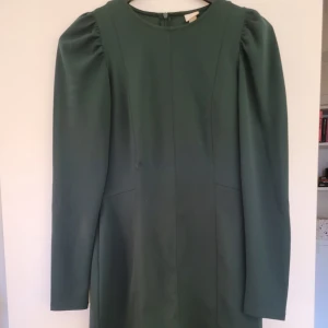 Höstgrön klänning! - Jättefin klänning i knälängd, i höstens trendiga grönt. Puffiga axlar och dragkedja i rygg. Mycket fint skick!