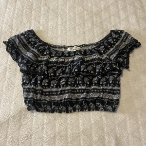 Söt topp 🖤 - Supersöt off-shoulder topp med mönster och volanger, sitter som en magtröja, fint skick, storlek 36 och är stretchig! <3 DM vid frågor osv! 