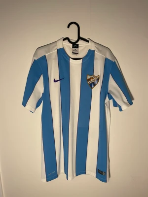 Fotbollströja Malaga 16/17 - En ikonisk tröja från ett av 2010-talets mest oväntade lag. Malaga nådde höjder som ingen trodde. Ett måste för en samlare eller nån som bara vill ha en vacker tröja