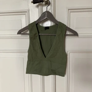 Grönt linne  - Ett grönt linne som funkar både att gå hemma i men också för att träna i. Storlek M 