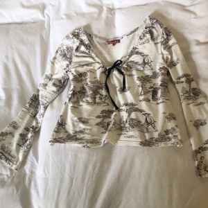 Vintage långärmad rosett topp  - Vintage Crocker topp (90-tal) i bra skick. Storlek L, true to size. Flare ärmar. Toile de jouy mönster. Silkes rosett. Finns inga bilder på men Dma gärna vid andra frågor eller funderingar. Köparen står för frakt.