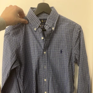 Randig blå Ralph Lauren skjorta - En otroligt fin, slimmad och modern skjorta från Ralph Lauren. Den är slim fit vilket gör den otroligt snygg.  Ny pris 1399kr Skjortan är i jätte bra skick! Och bara använd under speciella tillfällen!   Hörs gärna av vid frågor!:)