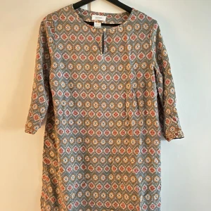 Retroinspirerad Midi-klänning - Retroinspirerad Midi-klänning i Storlek S/M Trekvartsärm  Blått dekorativt sidenband i fållen nedertill  Knapp i halsringen Endast använd fåtalgånger utan synliga tecken på användning 