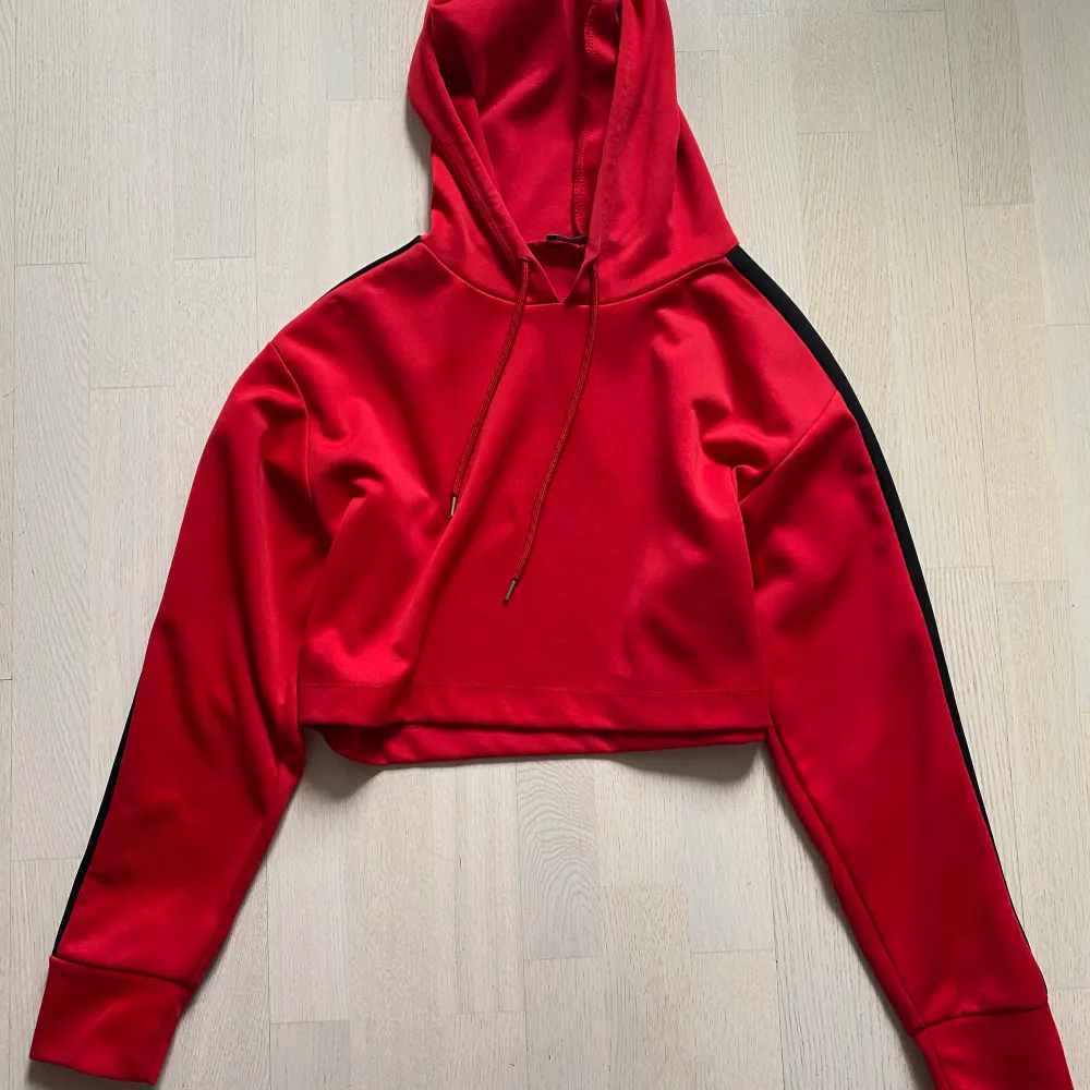 En kort röd snygg hoodie i mycket bra skick. För liten för mig. . Hoodies.