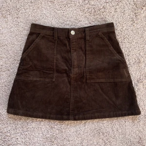 Brun manchesterkjol  - Brun minikjol i manchester från Monki. Använd några gånger men den är i fint skick! Storlek 38 men den är mer som en 36