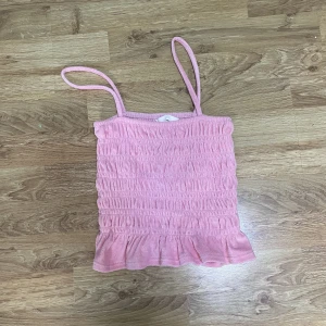 Rosa topp - Rosa skrynklig topp med volang nere.