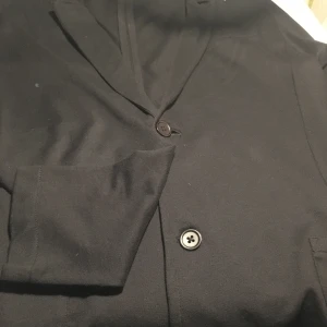 Tunn kavaj - En tunn svart kort kavaj. Använd typ två gngr. I nytt skick. 