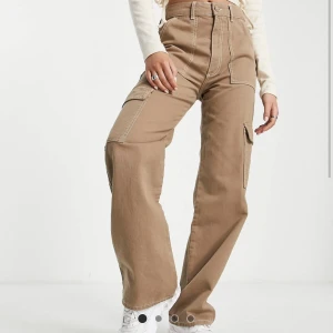 Bruna cargobyxor i strl S & M - 2 bruna cargobyxor med raka ben i strl. S samt ett par i strl. M. Oanvända. 