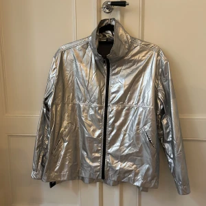Silvrig Sportjacka Björn Borg - Silvrig Sportjacka från Björn Borg. Lite skrynklig, annars som ny :) Rymlig storlek, passar även någon som är 38-40 i överdel beroende på hur oversize man vill att den ska sitta! 