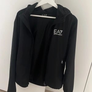 EA7 jacka - Tjena! Säljer denna sjukt snygga och sköna jackan som är i ett mycket bra skick då den inte kommit till mycket användning. Retail: 1700 