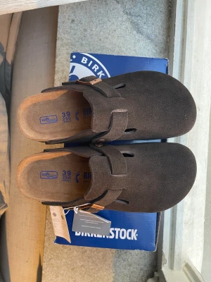 Birkenstock Suede  - Säljer ett par helt oanvända Birkenstock Boston Suede i storlek 39. Nypris är 1715 kr. De är i färgen Mocha och jag både frakta dem eller mötas upp!