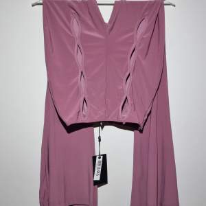 Dusty pink/syrenlila utsvängda leggings med hög midja och hålmönster på framsidan. Unik design i modern bohemisk stil 