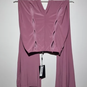 Utsvängda byxor med utskurna detaljer - Dusty pink/syrenlila utsvängda leggings med hög midja och hålmönster på framsidan. Unik design i modern bohemisk stil 