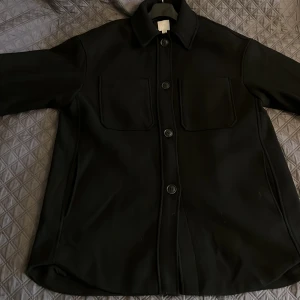 Svart Oversized Kappa - Stilren och trendig oversized kappa i helt nyskick, endast använd 1 gång. Säljer den då den tyvärr är för stor för mig. 