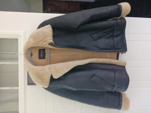 Mörkbrun äkta pilotjacka.  - Den perfekta pilotjackan i Mörkbrunt läder. Insidan är fårskinn. Metalldetaljer på sidorna och vid halsen. 