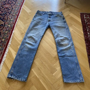 Wrangler jeans  - Straight wrangler jeans i snyggaste denim och slitage. 32/34. En lagning vid knäet. Pris: 199kr