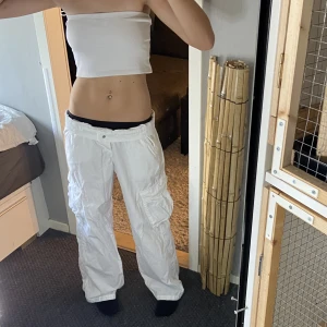 Cargopants  - Vita cargopants som nästan är som linnebyxor i materialet. Lowaisted, har vikt ner kanten på bilderna. Midjemått tvärsöver:42  Innerbenslängd: 79 Står 42 men skulle själv säga S/M