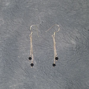 Dangly örhängen - Super söta silvriga dangly örhängen med svarta pärlor på botten, aldrig använda, säljs eftersom ja har töjt mina öron o kan inte ha örhängen längre💕