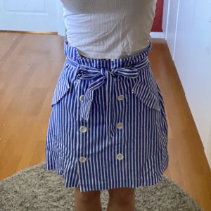 Kjol i blå och vit - Jättefin kjol från zara med knappar och knytning. Storlek S. 