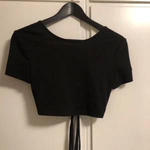 Svart öppenrygg topp - En svart topp ifrån shein med öppen rygg och snören. Den är aldrig använd då den är för liten. Den är endast testad.