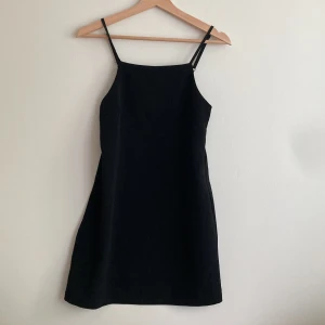 Kort klänning - Svart, kort klänning från Monki, storlek 34. Ej elastisk men det finns en kort dragkedja på vänster sida.