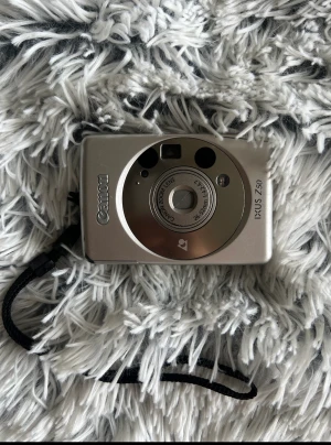 Kamera - Canon IXUS Z50 filmkamera från 90talet. Kan ej garantera att den fungerar då jag ej själv testat.   Finns ingen laddare,batteri,film med. 