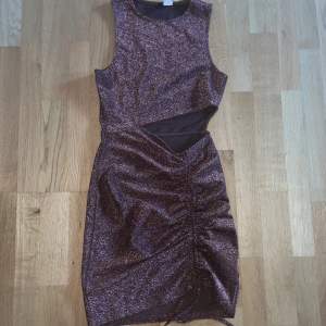 En brun glittrig klänning från H&M. Storlek XS. Säljer pga för liten för mig. Använd 2 gånger så den är i nyskick. Köparen står för frakt. Kan även mötas upp i Varberg.