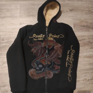 Really Point hoodie - En fet Really Point tröja från skaparen Christian von Audigier. Passar bra på vintern då insidan är varm och skön.  Går att matcha till vilken årstid som helst.   Storleken är XXL men är knappt oversized på mig som vanligtvis använder L. 