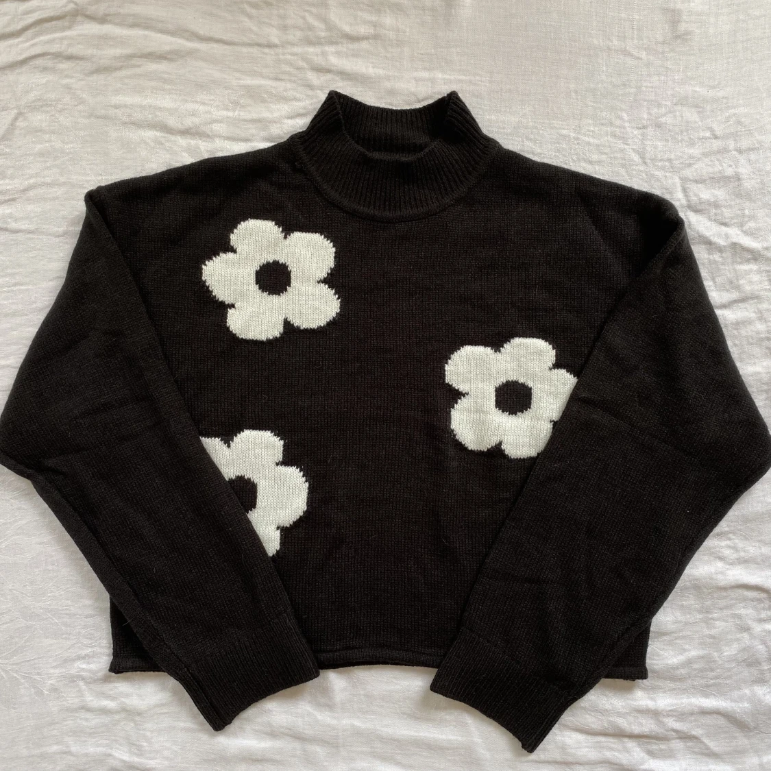 Svart stickad tröja med vita blommor