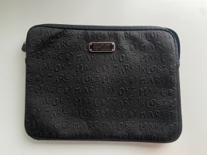 Marc jacobs datafodral - Säljer detta supersnygga och eftertraktade datafodral som jag köpte på plick💗 Dragkedjan är sönder men borde gå att lämna in och fixa. Den har också lite defekter som syns i bild 2 men som inte är märkbara❤️