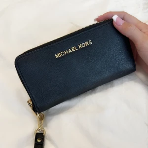 Michael Kors plånbok  - Säljer min Michael Kors plånbok då den tyvärr inte används längre. Den är i jätte fint skick, enda som slits lite är metallen på dragkedjan (syns i andra bilden). Skriv för frågor eller fler bilder🩷