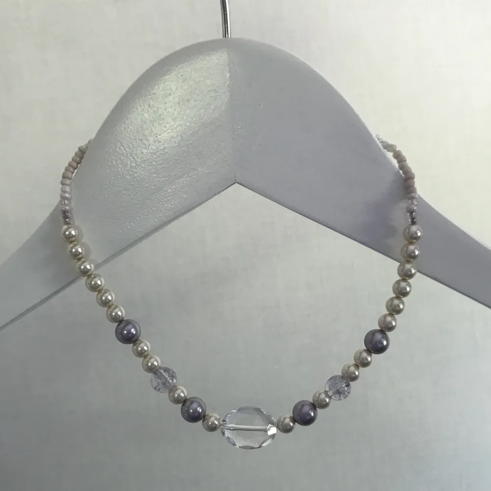 Halsband gjort av både stora och små pärlor i färgerna lila, grå , transparant, vit och ljusrosa.  Gjort av tunn silvrig ståltråd och är handgjort. Köpare står för frakt. . Accessoarer.