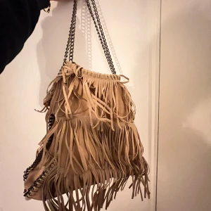 Väska med fransar  - Jättefin beige väska med fransar. Den är ganska stor och får plats med mycket!! Bra skick😙🥰
