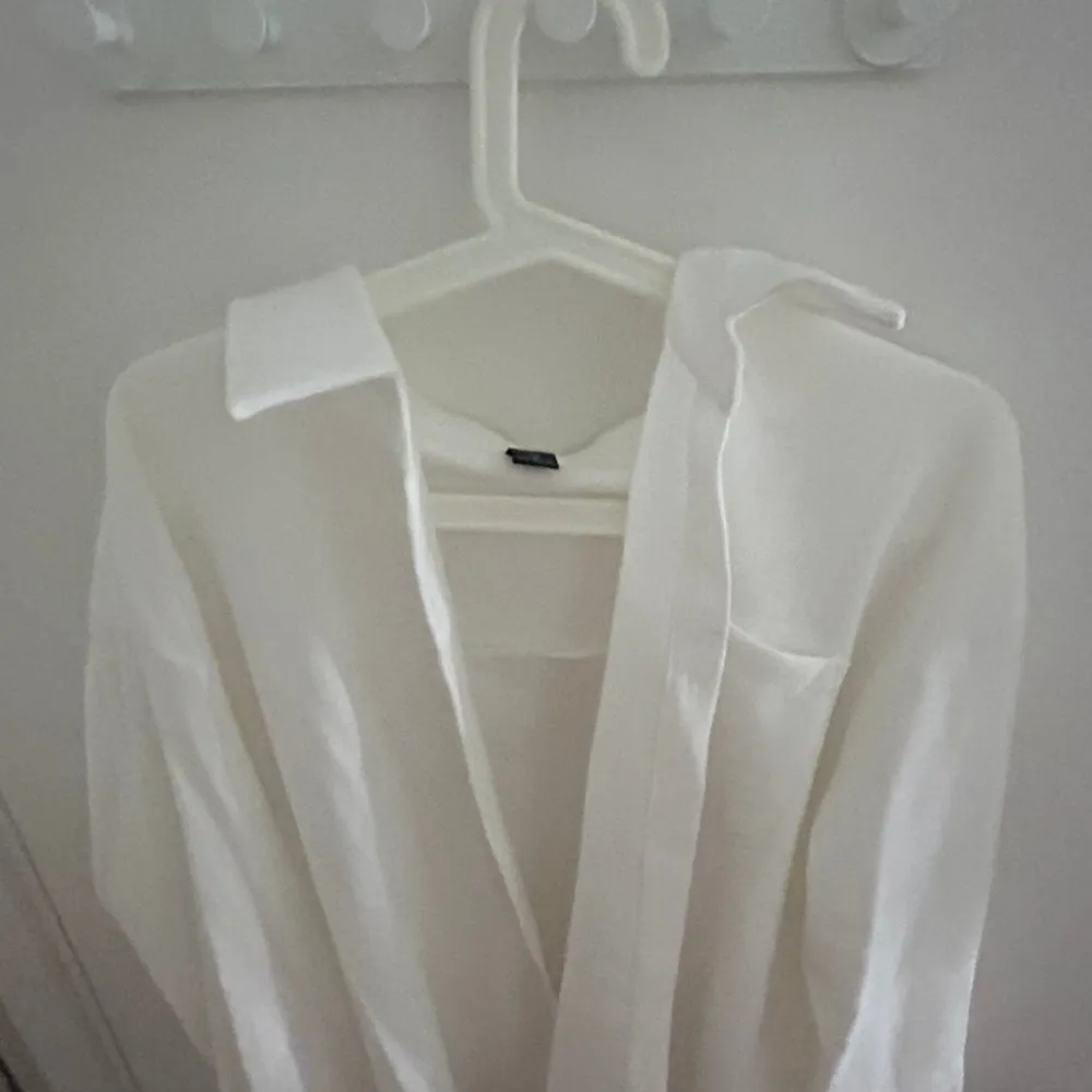 En vit skjorta som är använd en gång, jag hade den över en sommar klänning och den är inte obekväm alls. Jätte bra skick. Skjortor.