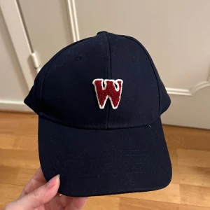 Marinblå keps med brodering - Marinblå keps med brodering, osäker på storlek. 