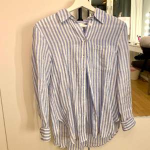 Blå-vitrandig skjorta i 100% linne från HM. Använd ca 1 gång. Storlek XS men är lite stor i storleken. Hör av dig för fler bilder💖