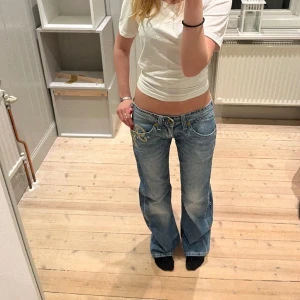 Lågmidjade G-Star Raw jeans - Jätte snygga ljusblåa Lågmidjade G-Star Raw jeans med unikt tryck! Säljer på grund av att de är för stora på mig. Köpta second hand i Paris och de har aldrig använts av mig samt har inga defekter! Ge gärna prisförslag eller skriv innan ni trycker på köp😊