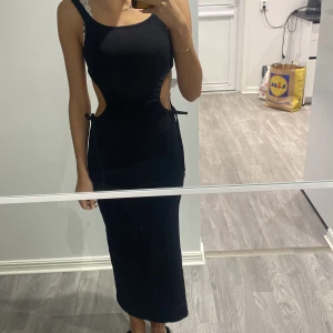 Klänning  - Aldrig använd, skönt material, bra passform, öppet vid sidorna som går att justera 